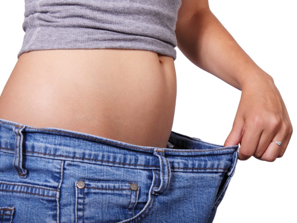 Woman checking fat loss around waist