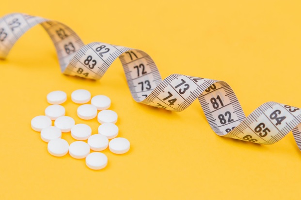 Weight loss pills and measure tape