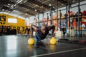 Man doing a plank with kettle balls