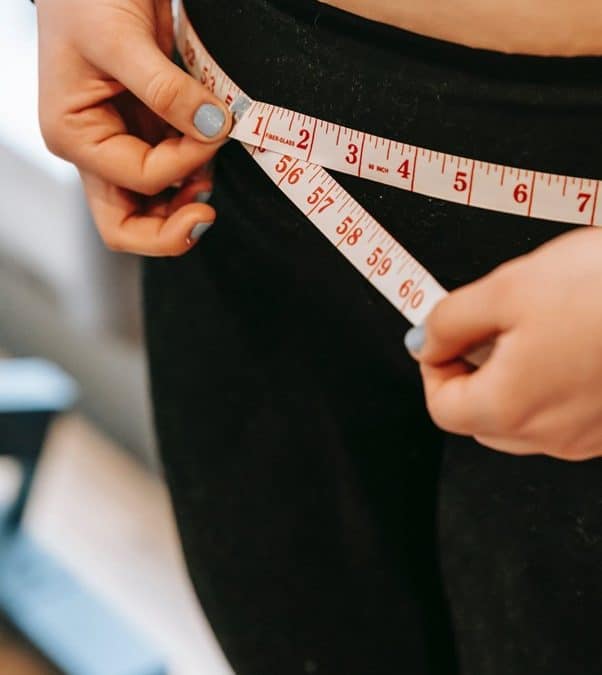 woman measuring waist after following 5 weight loss tips