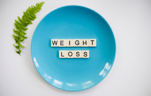 Blue plate with the letters Weight loss arranged on it