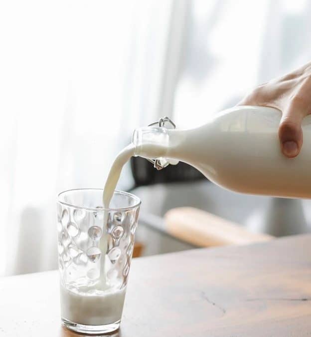 Pouring oat milk in a glass