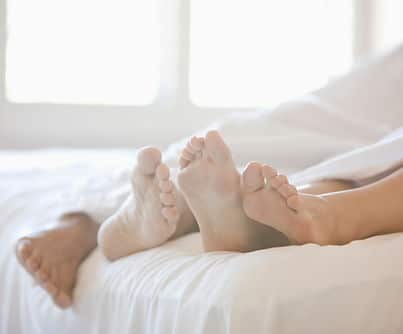 Couple’s Feet in Bed